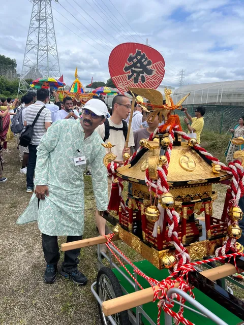 金色の神輿と、インドのラタが同じ会場に並ぶ様子